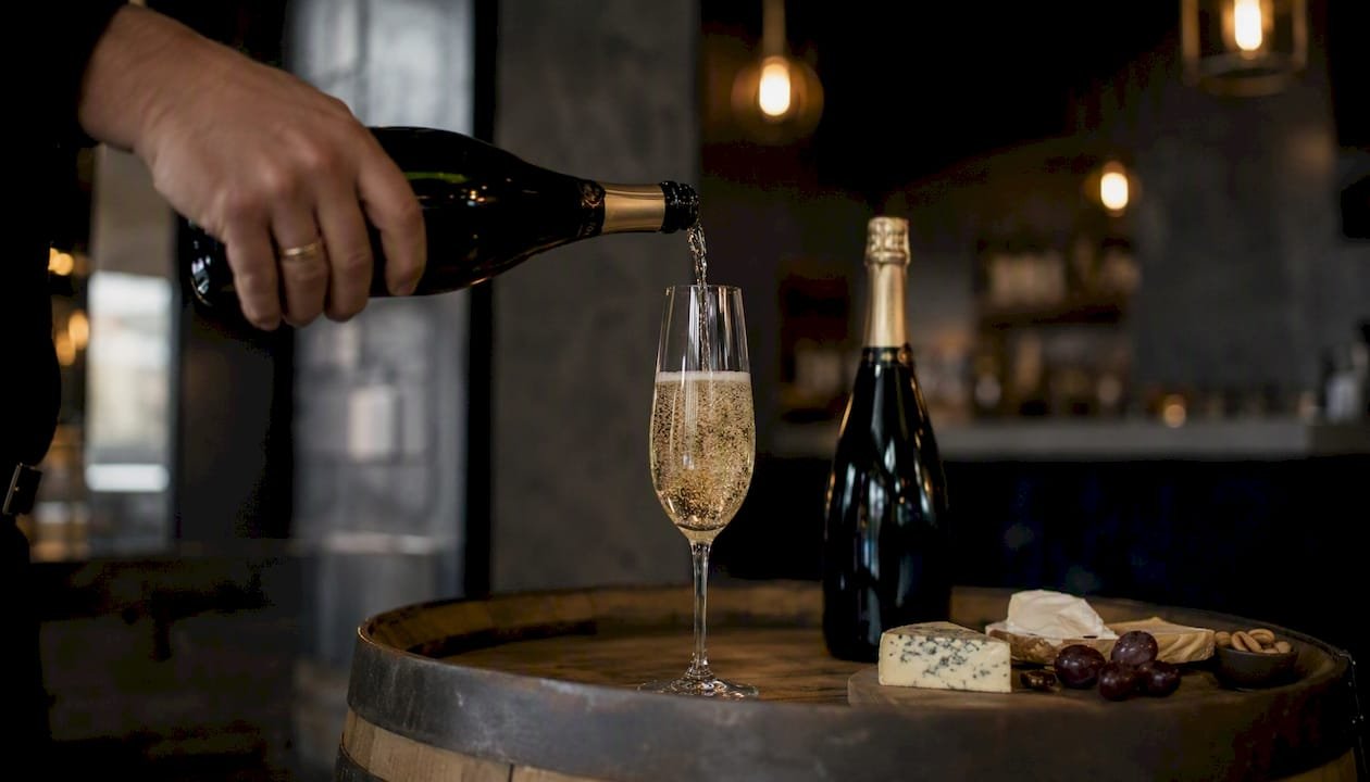Hand pouring English sparkling wine into flute