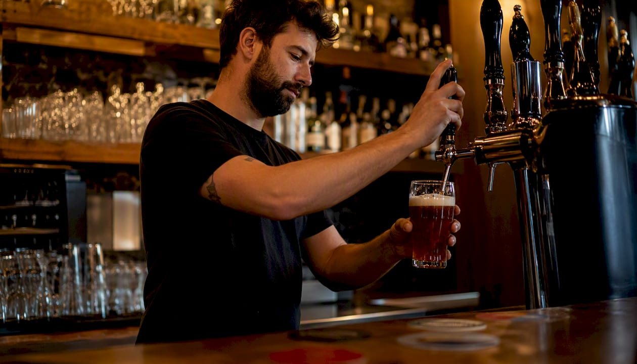 Pouring British ale into pub glass