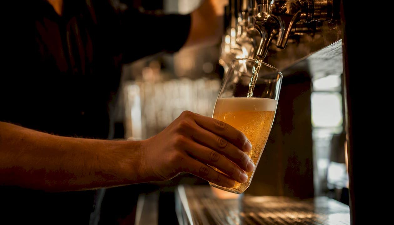 Close-up of craft beer pouring at taproom bar