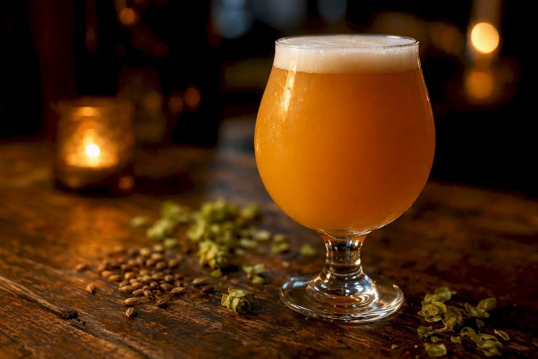 Glass of hazy NEIPA with oats and hops